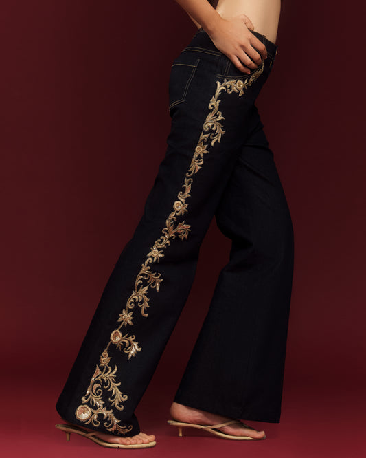 Close-up of gold dabka embroidery and hand-sewn sequins on dark indigo denim.