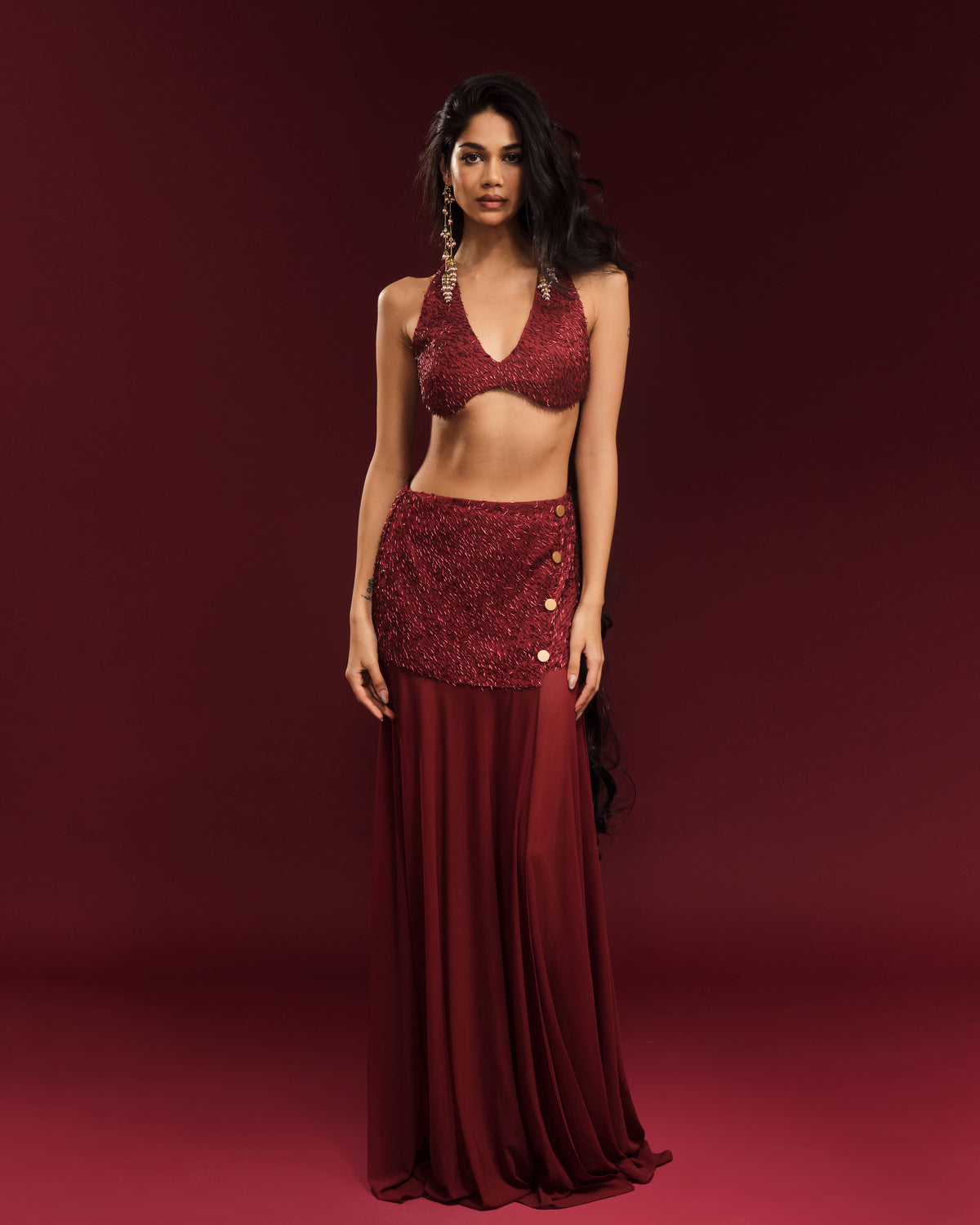 Wine-red floor-length skirt with a statement slit and decorative gold-tone buttons.