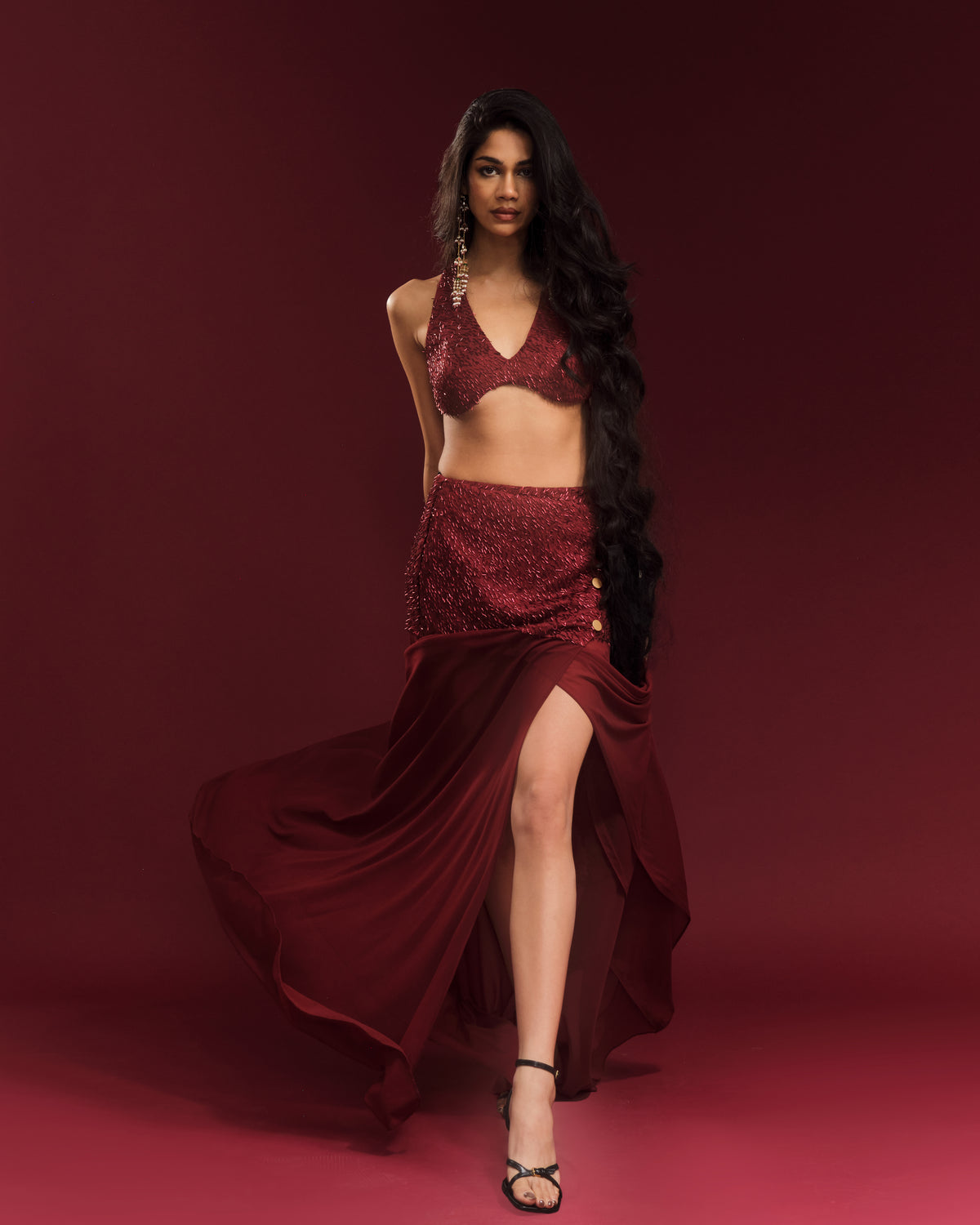 Wine-red festive co-ord featuring an embellished halter blouse and flowing maxi skirt.