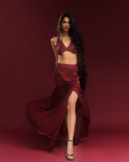 Wine-red festive co-ord featuring an embellished halter blouse and flowing maxi skirt.