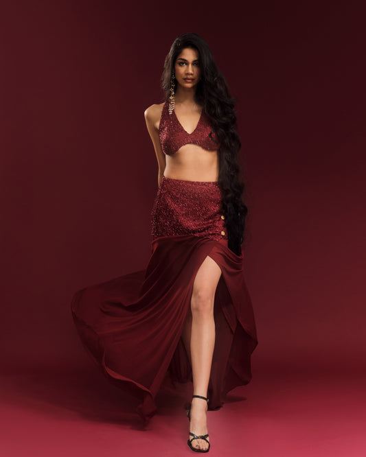 Wine-red festive co-ord featuring an embellished halter blouse and flowing maxi skirt.