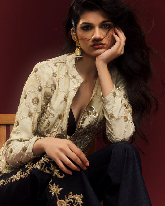 Cropped silk jacket featuring intricate gold embroidery and a front zipper.

