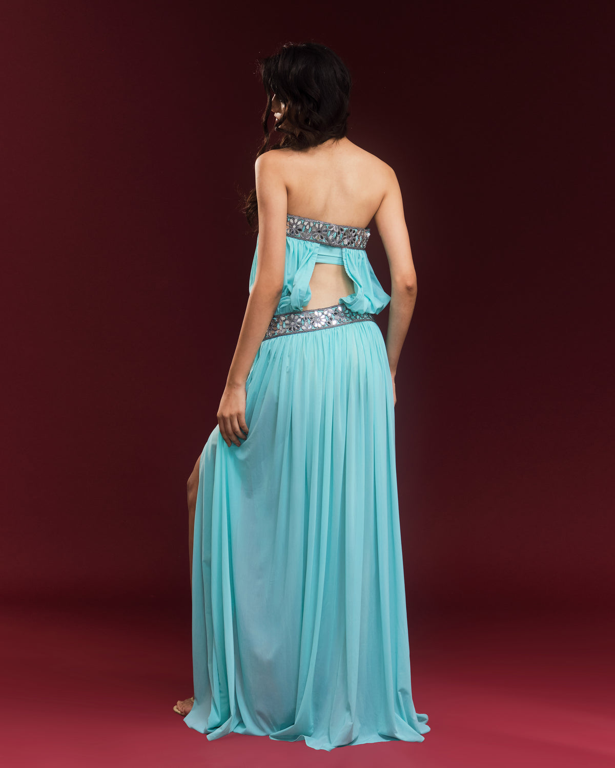 Back of the turquoise Jasmine Bonded Dress featuring an open-back silhouette and draped fabric.

